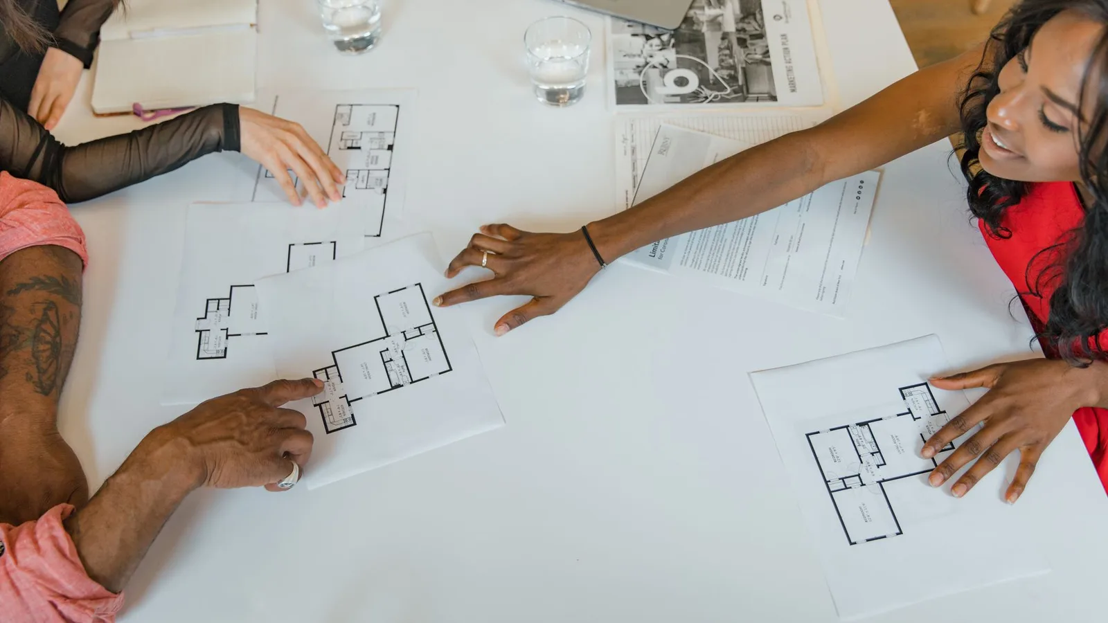 Equipo de consultoría inmobiliaria analizando planos e información de mercado
